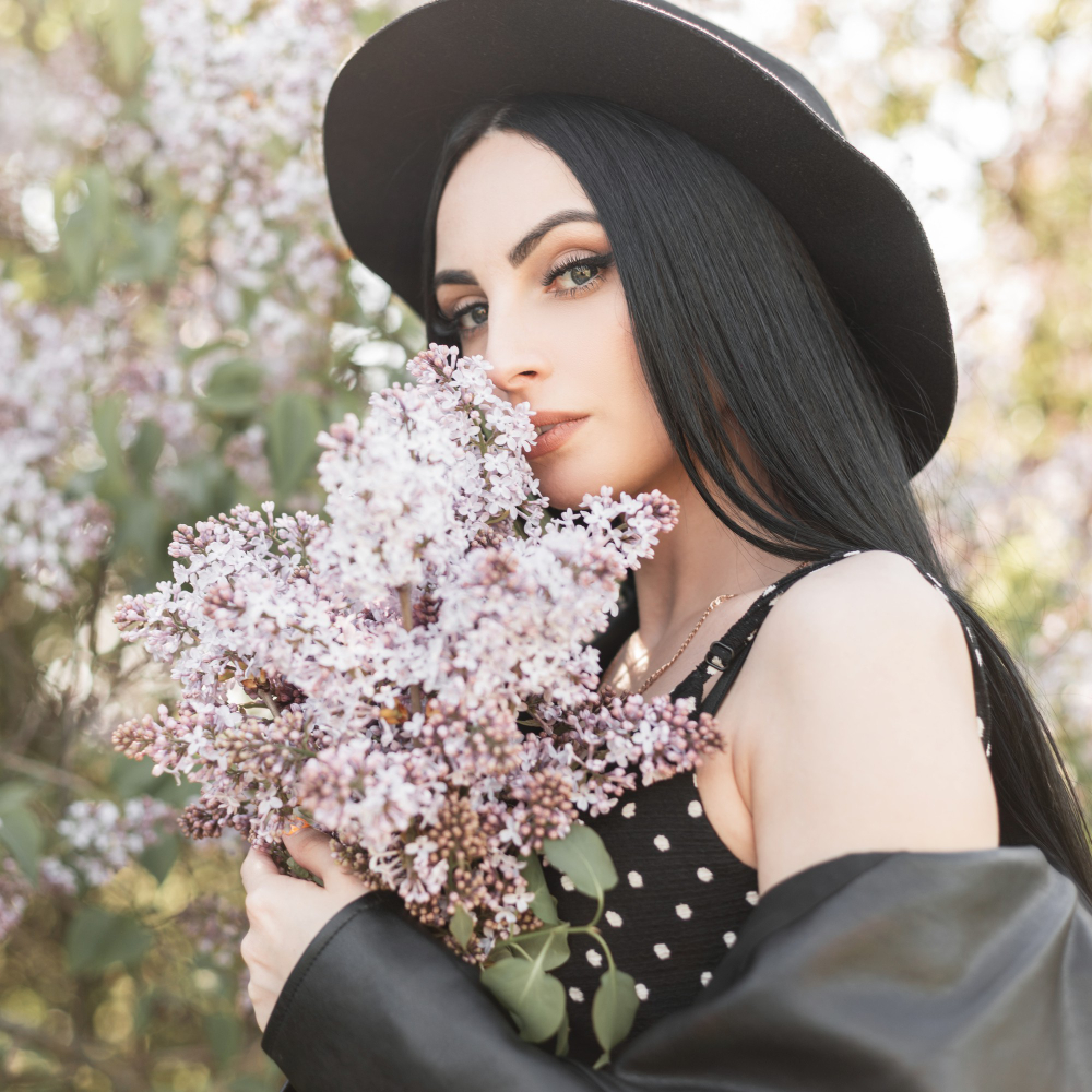 young-woman-flowered-park-rests-nature-fashionable-girl-elegant-hat-trendy-black-dress-lilac-spring-flowers-outdoors-gorgeous-lady-sniffs-amazing-bouquet-flowers-sunny-fresh-portrait